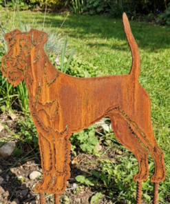 Metalen Irish Terrier silhouet met natuurlijke roestpatina geplaatst in een bloembed