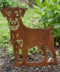 Metalen Duitse Jachtterriër silhouet met natuurlijke roestlaag tussen planten in de border